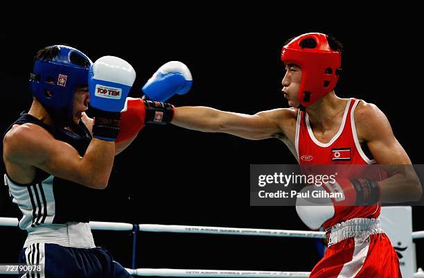 Kim Song Guk of Peoples Democratic Republic of Korea hits Bahodirjon Sultonov of Uzbekistan in the Men's 57kg Semi Finals Boxing during the 15th...
