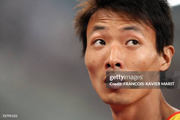 China's Yang Yaozu looks up after winning in the men's 200m heat 1 event on the third day of the athletics competition for the 15th Asian Games at...