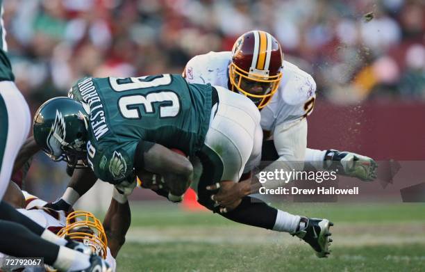 Running back Brian Westbrook of the Philadelphia Eagles gets tackled by safety Sean Taylor of the Washington Redskins at FedEx Field December 10,...