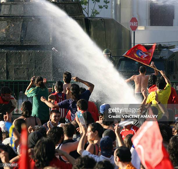 An anti riot water canon vehicle disperses Anti Pinochet Chileans who jubilate after having the confirmation of Augusto Pinochet's death, 10 December...