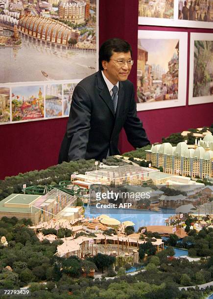 Genting Group chairman, Lim Kok Thay, poses next to the proposed model for the Integrated Resort on Sentosa Island in Sinagpore 11 December 2006....