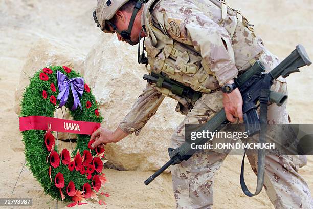 Panjwayi, AFGHANISTAN: Canadian soldier, joined by personnel from British, US, and Afghan forces, lays a wreath during a Remembrance Day ceremony at...