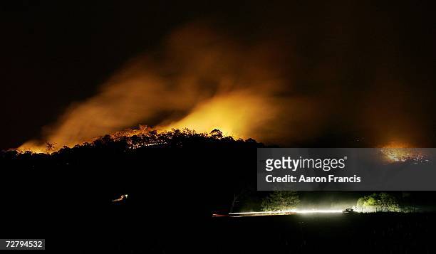 Fires in the hills surrounding Alpine Village in Mount Beauty on December 11, 2006 in Melbourne, Australia continue to burn into the night as they...