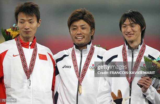 Japan's Shingo Suetsugu poses with China's Yang Yaozu and compatriot Japan's Shinji Takahira at the awards ceremony for the men's 200m final on the...