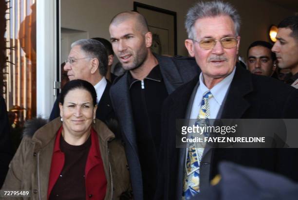 French football star Zinedine Zidane is joined by his father Smail and mother Malika as they pose for a picture upon their arrival at the Houari...