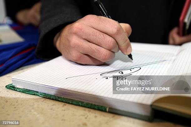French football star Zinedine Zidane signs a guest book during his visit to a local clinic in Sidi Daoud village, 100 KM eastern Algiers City, 11...