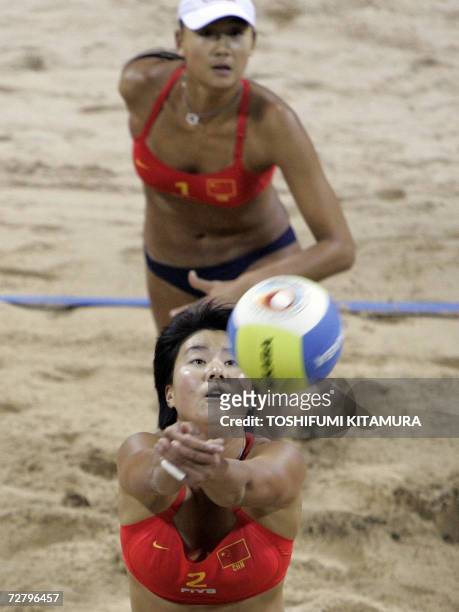 China's Zhang Xi receives a ball as partner Xue Chen watches during their women's beach volleyball gold medal match at the 15th Asian Games in Doha...