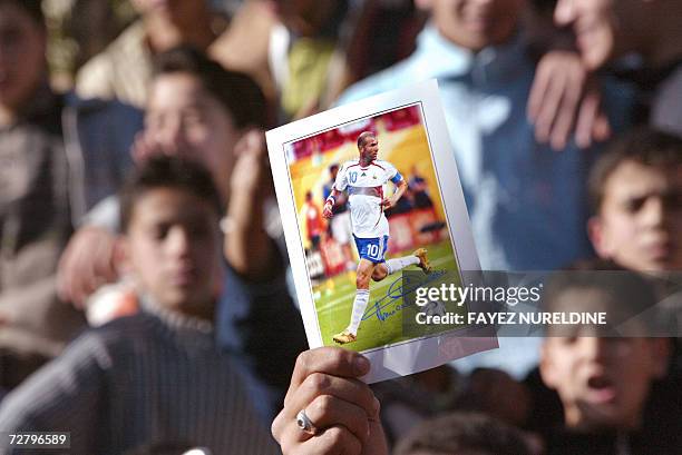 An Algerian supporter holds a picture of their favorite football star French Zinedine Zidane 11 December 2006 during his visit at a local clinic in...