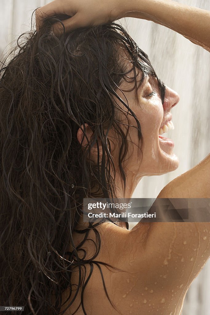 Woman in shower, hands in hair, close-up