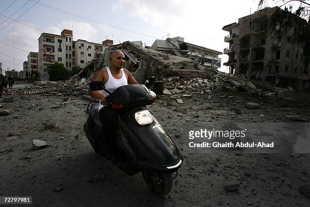 Lebanese fighter speeds away on his motorbike after Israeli jets flattened a Hizbollah compound on August 07, 2006 in Tyre, Lebanon.