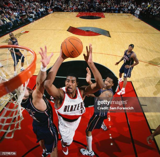 LaMarcus Aldridge of the Portland Trail Blazers takes the ball to the basket against Nenad Krstic and Mikki Moore of the New Jersey Nets during a...