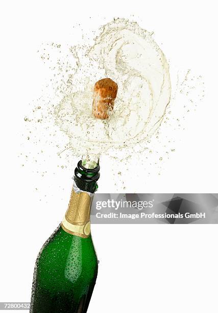 cork flying out of a sparkling wine bottle - tappo di champagne foto e immagini stock