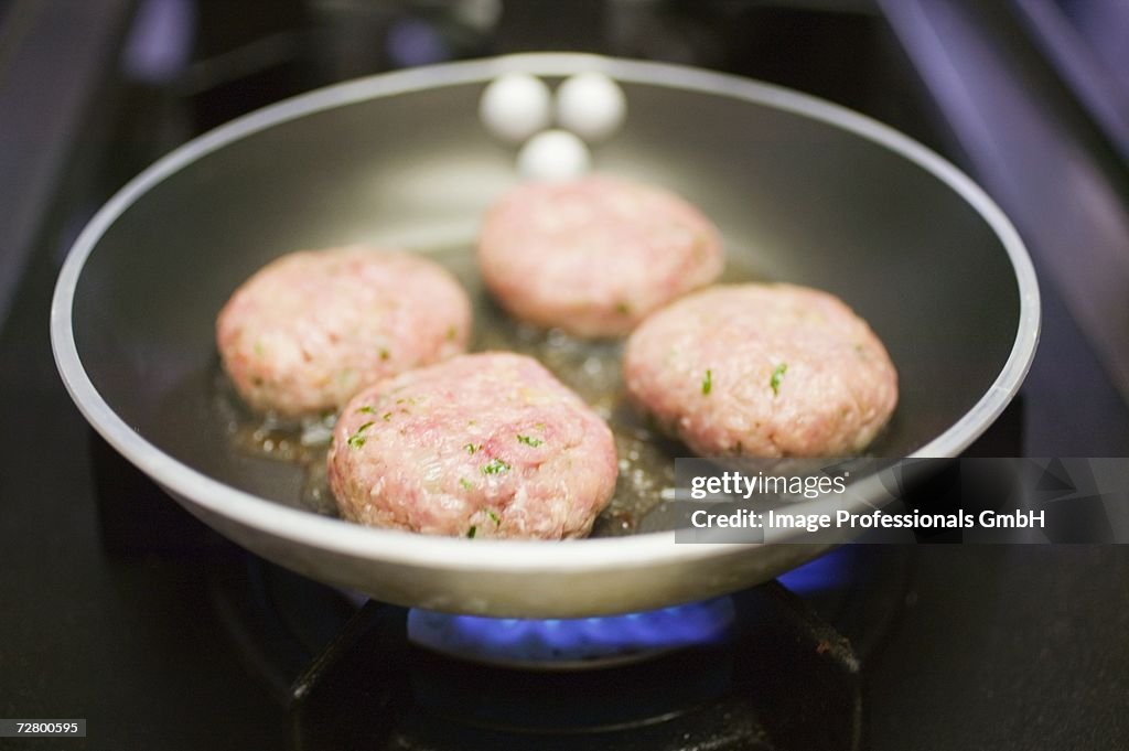 Frying burgers in a frying pan