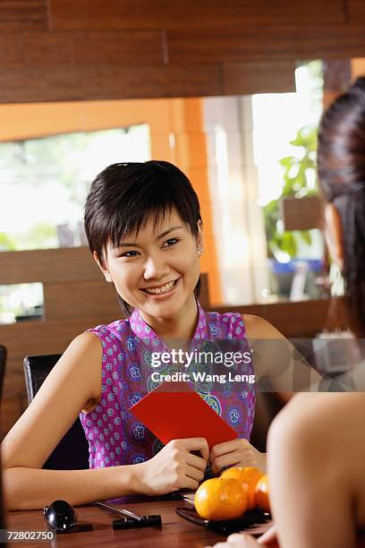 two girls sitting opposite each other, oranges on the table between them - mad about heritage festival stockfoto's en -beelden