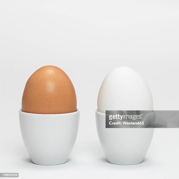 white and brown organic eggs in eggcup - eierbecher stock-fotos und bilder