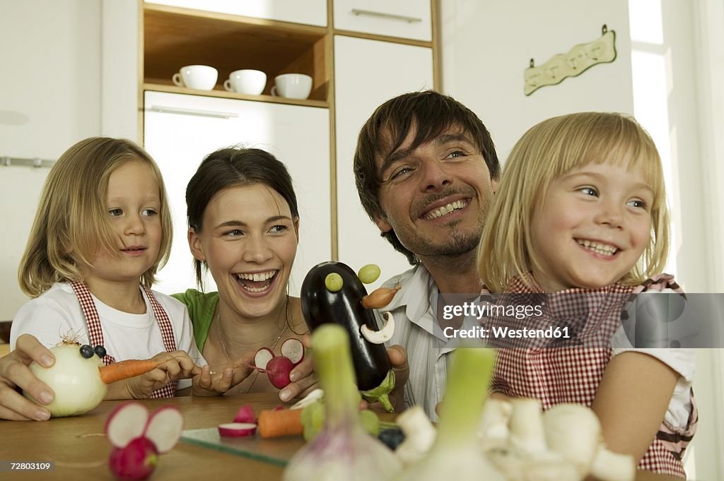 Familiy in kitchen, playing with children