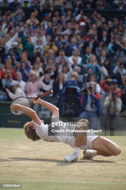 Swedish tennis player Stefan Edberg kneels back on the grass in celebration upon winning the Gentlemen's Singles Challenge Cup Trophy after defeating...