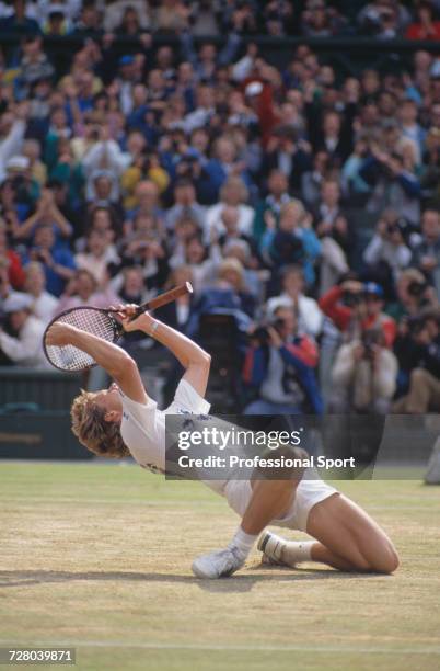 Swedish tennis player Stefan Edberg kneels back on the grass in celebration upon winning the Gentlemen's Singles Challenge Cup Trophy after defeating...