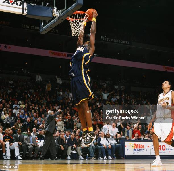 Jermaine O'Neal of the Indiana Pacers takes the ball to the basket past Matt Barnes of the Golden State Warriors during a game at Oracle Arena on...