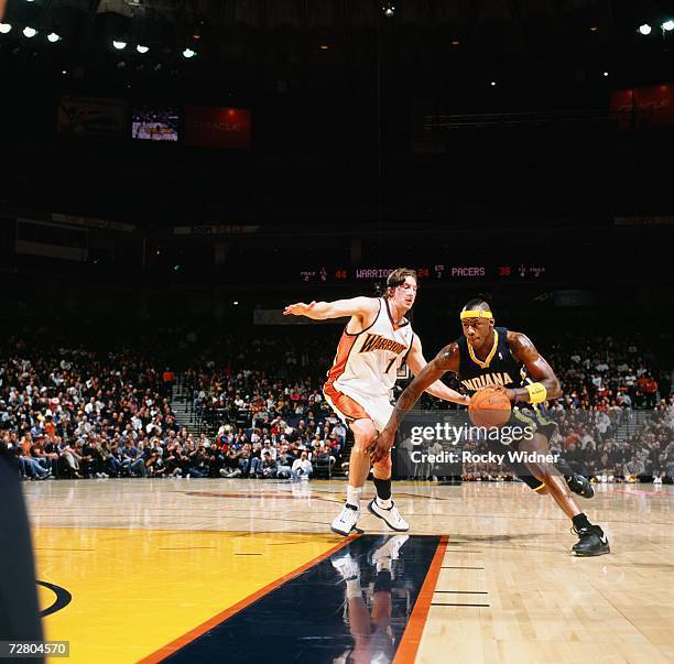 Al Harrington of the Indiana Pacers drives to the basket past Troy Murphy of the Golden State Warriors during a game at Oracle Arena on November 29,...