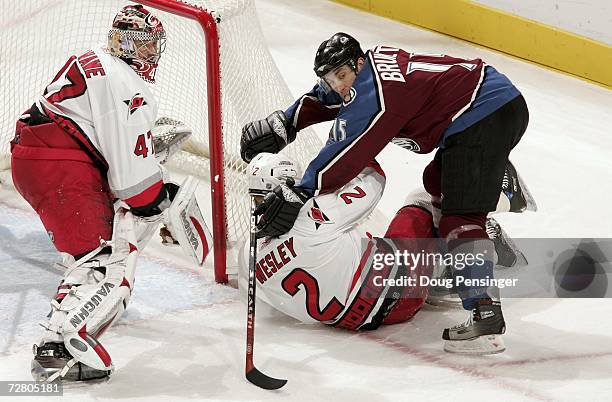 Andrew Brunette of the Colorado Avalanche and Glen Wesley of the Carolina Hurricanes get tangled up as goaltender John Grahame protects the goal...