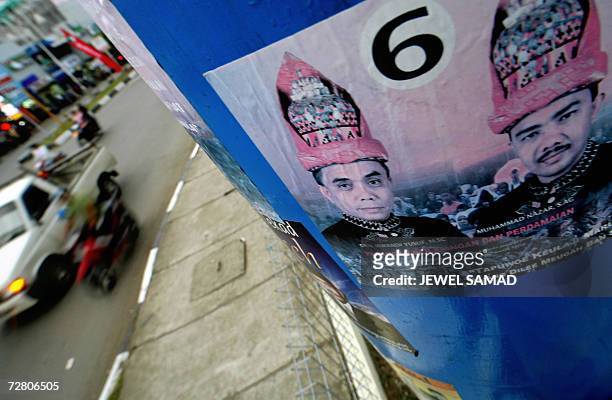 Banda Aceh, INDONESIA: Motorists pass by an electoral poster of Irwandi Yusuf , the former spokesman of the Free Aceh Movement and a front running...