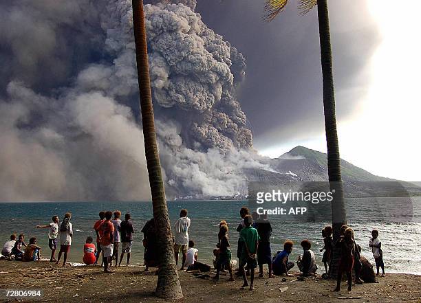 Rabaul, PAPUA NEW GUINEA: Evacuated Matapit Islanders watch Tavurvur volcano erupt sending ash and rocks over the already devastated city of Rabaul...