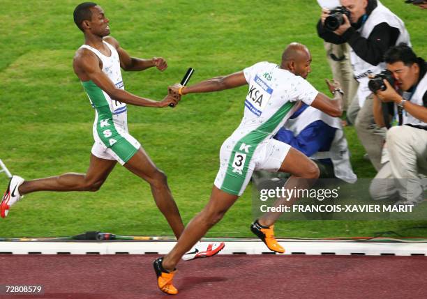 Saudi Arabia's Mohammed O. Al-Salhi hands the baton to teammate Hamdan Awdah Al-Bishi for the final leg of the men's 4x400m relay final on the fifth...