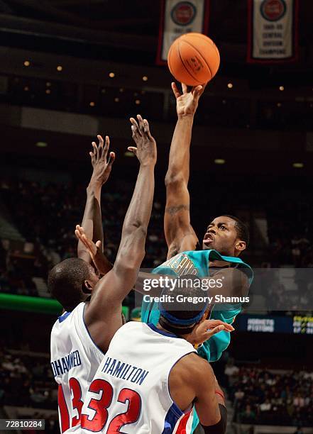 Desmond Mason of the New Orleans/Oklahoma City Hornets puts up a shot over Nazr Mohammed and Richard Hamilton of the Detroit Pistons on November 15,...