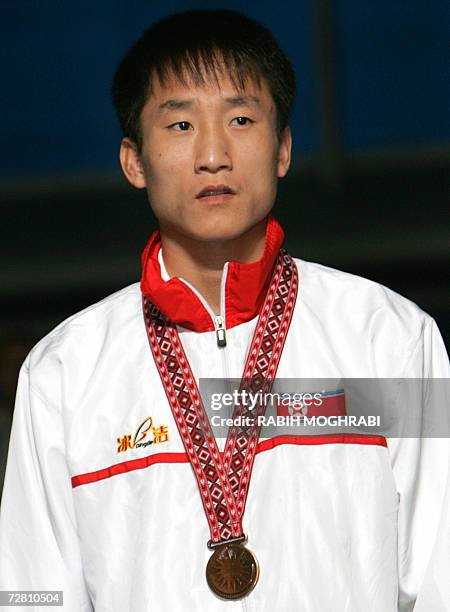 North Korea's Kim Song-Guk poses at the awards ceremony with his bronze medal for the featherweight 57kg boxing final bout at the Aspire Hall for the...