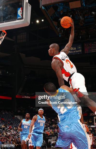 Marvin Williams of the Atlanta Hawks dunks over Marcus Camby of the Denver Nuggets at Philips Arena on December 12, 2006 in Atlanta, Georgia. NOTE TO...