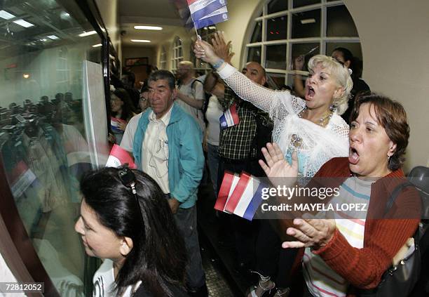 Decenas de personas gritan consignas contra el Tratado de Libre Comercio entre Costa Rica y Estados Unidos el 12 de diciembre de 2006 en la "barra"...