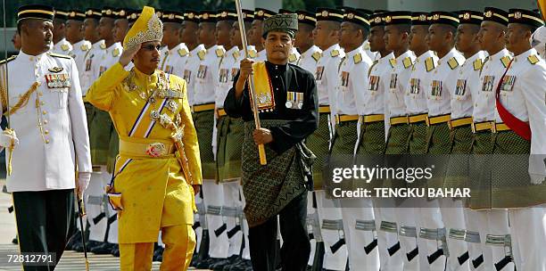 Kuala Lumpur, MALAYSIA: The thirteenth King of Malaysia Sultan Mizan Zainal Abidin salutes as he inspects the Royal Guard of Honour at the Parliament...