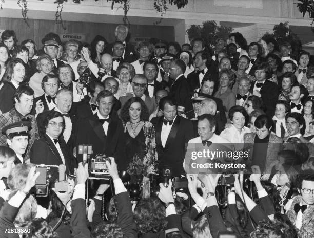 French film star Jean-Paul Belmondo faces the photographers at the Cannes Film Festival with Italian actress Laura Antonelli after a screening of his...