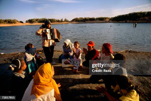 Schoolgirl plays the accordion during a picnic by Ein Dabban Lake April 2000 in Ein Dabban Lake, Libya.
