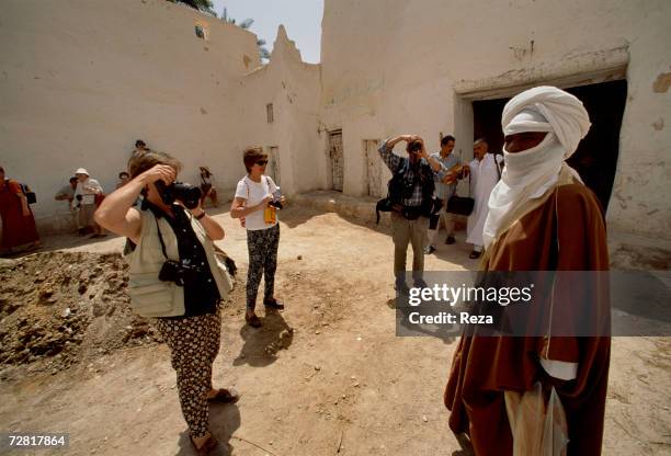 Tourists visiting the old town take pictures of a Tuareg April 2000 in Ghadames, Libya.