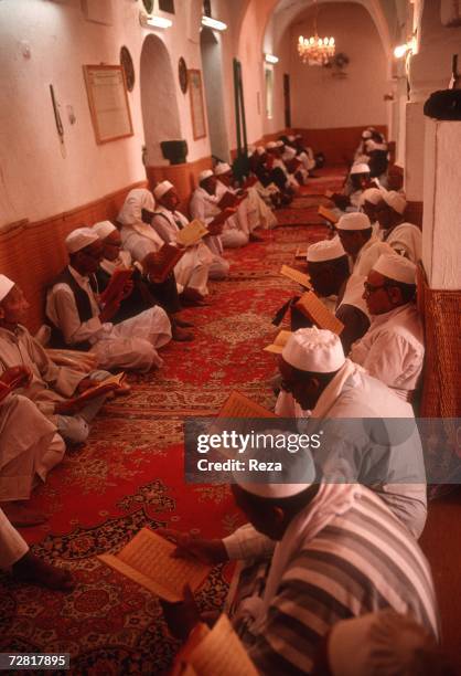 During a mourning, men read prayer books during a religious gathering to present condolences to the deceased's family, April, 2000 in Ghadames, Libya.