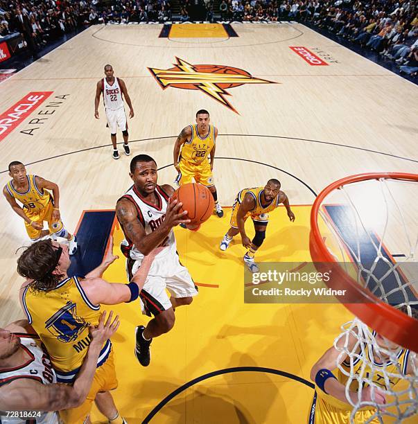 Maurice Williams of the Milwaukee Bucks takes the ball to the basket against Troy Murphy of the Golden State Warriors during a game at Oracle Arena...