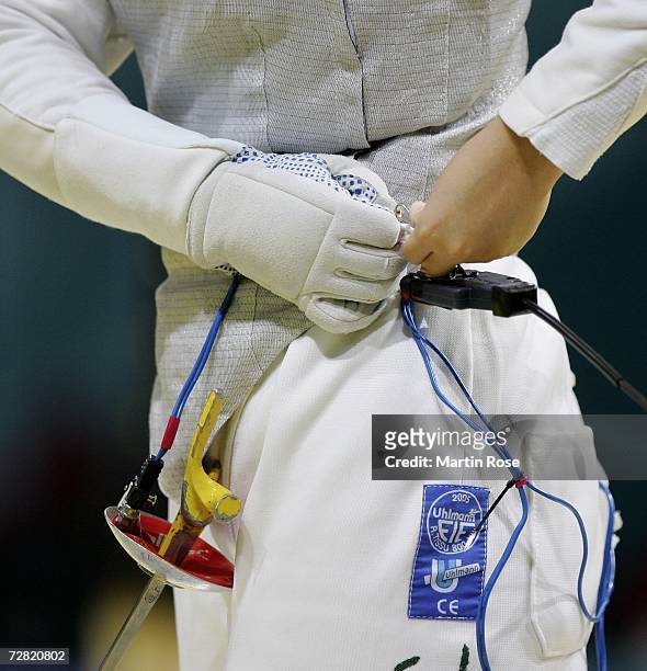 Competitor connects their electronic tagging system during the Women's Fencing Team Foil during the 15th Asian Games Doha 2006 at the Al-Arabi Indoor...