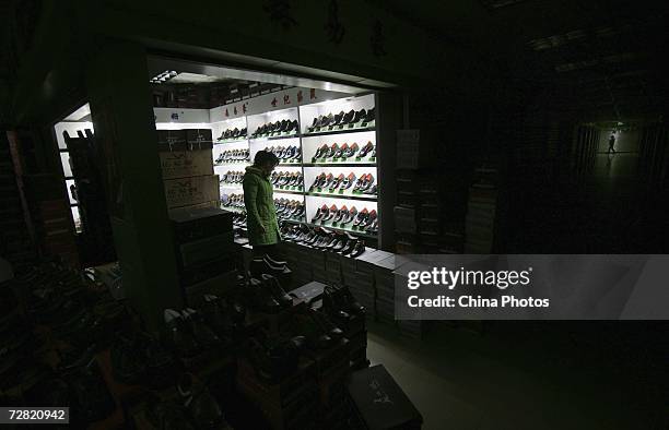 Vendor counts shoes before closing shop at Chaotianmen Wholesale Market on December 9, 2006 in Chongqing Municipality, China. Chinese shoemakers plan...