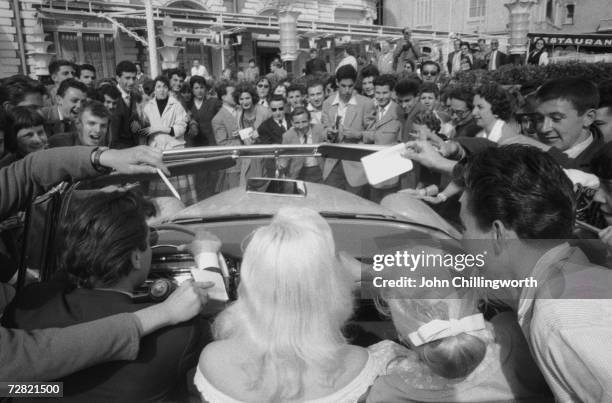 Blonde British actress Diana Dors is besieged by autograph hunters outside the Carlton Hotel during the Cannes Film Festival, 3rd May 1956. Original...