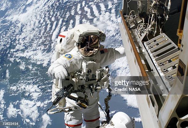 In this NASA handout photo astronaut Robert L. Curbeam, Jr., STS-116 mission specialist, prepares to replace a faulty TV camera on the exterior of...