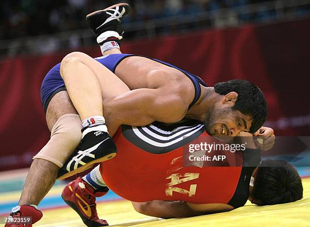 Kazakhstan's Leonid Spiridonov wrestles India's Sushil Kumar in the men's freestyle 66kg bronze medal wrestling match at the Aspire Hall for the 15th...