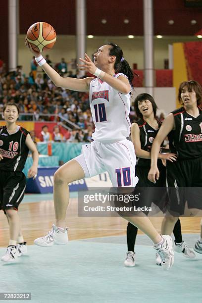 Beon Yeon Ha of the Republic of Korea drives to the basket against the defense of Ryoko Utsumi of Japan during the Women's Basketball Bronze Medal...