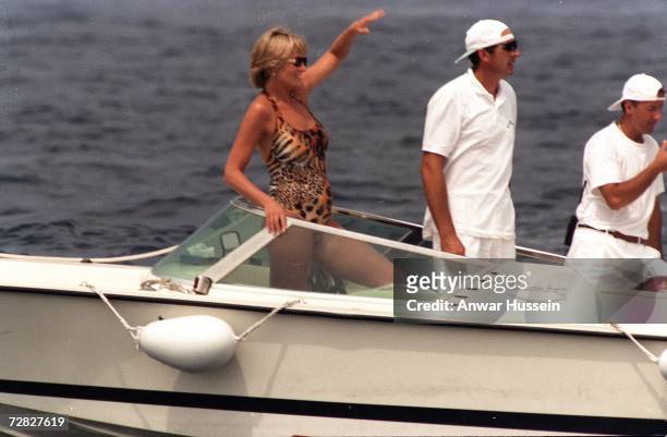 Diana, Princess of Wales, wearing an animal print, halterneck swimsuit and sunglasses, has fun on a boat on July 17, 1997 in Saint-Tropez, France.