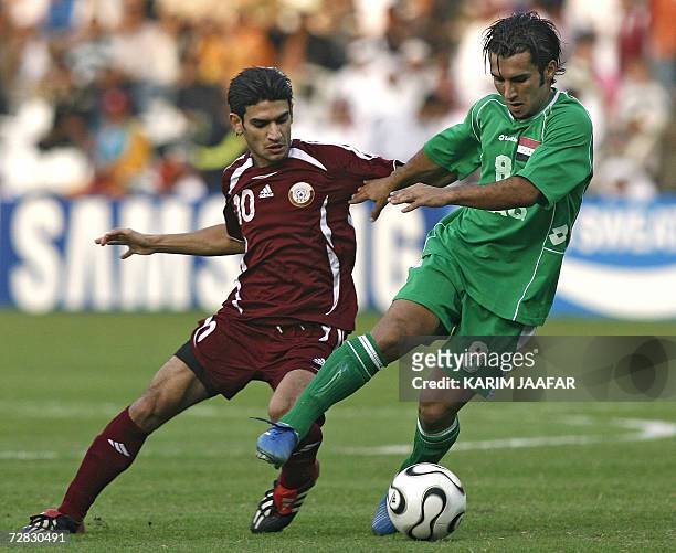 Iraq's Samer Mujbel is challenged by Qatar's Hussain Yaser Abdulrahman during the men's football final between Iraq and Qatar at Al-Sadd Sports Club...
