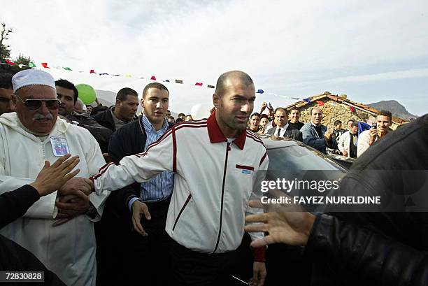 French football star Zinedine Zidane is escorted by relatives and fans upon his arrival to his family's home in Aguemoune, 300 kms east of Algiers...