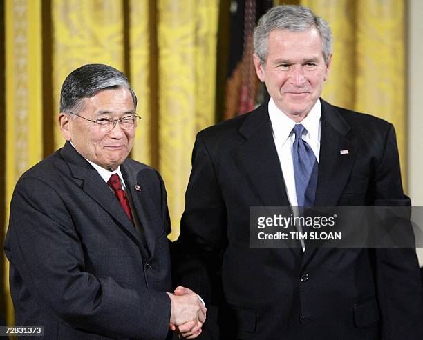 Washington, UNITED STATES: Norman Mineta , the longest serving secretary of transportation and former cabinet member shakes hands with US President...