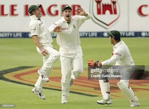 Wicket keeper AB de Villiers of South Africa celebrates the wicket of Sachin Tendulkar with captain Graeme Smith during Day One of the First test...