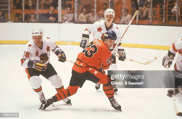 Mike Bossy of the Campbell Conference and New York Islanders skates on the ice as Marcel Dionne of the Wales Conference and Los Angeles Kings and...